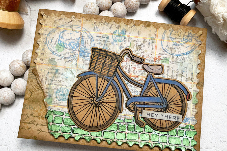 Mixed Media card featuring a bike and travel theme map background.
